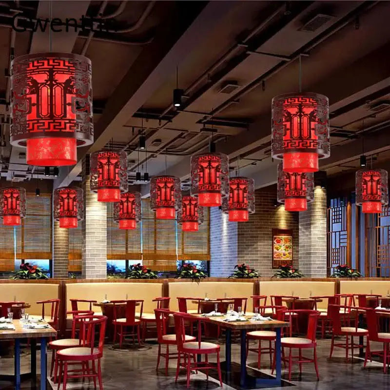 Red lanterns pendant lights with intricate black cut-out patterns from DecorBites antique wood pendant fixtures