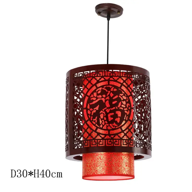 Red cylindrical pendant light with intricate dark brown metalwork and chinese character decorbites antique wood pendant