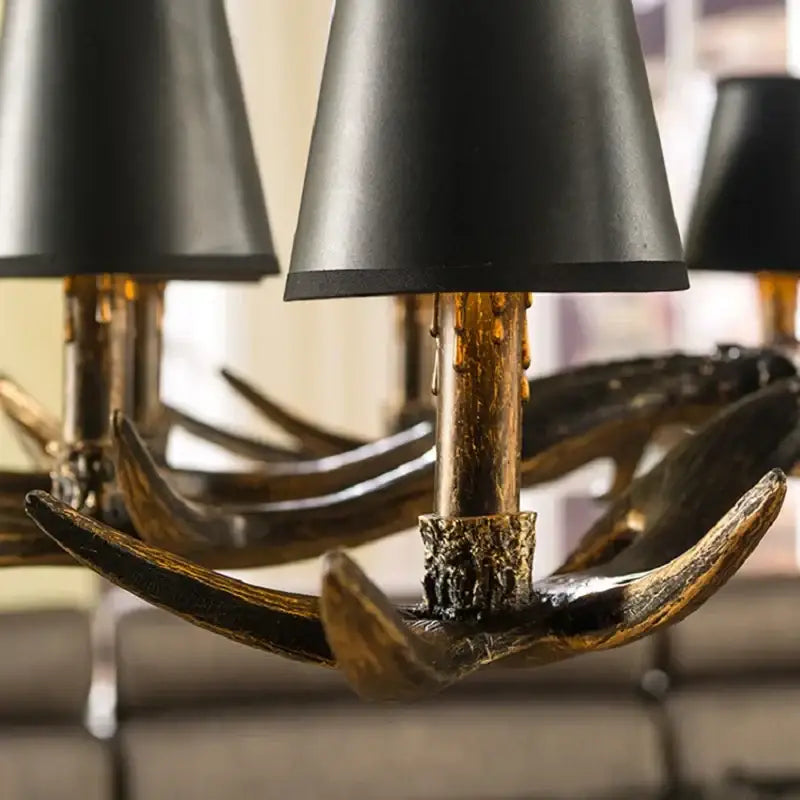 Black conical lamp shades rest atop golden resin antler arms in the DecorBites antler chandelier art deco design