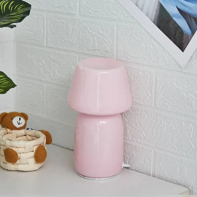 A sleek glossy pink ceramic table lamp with a mushroom-shaped design decorbites apollo mushroom glass bedside light