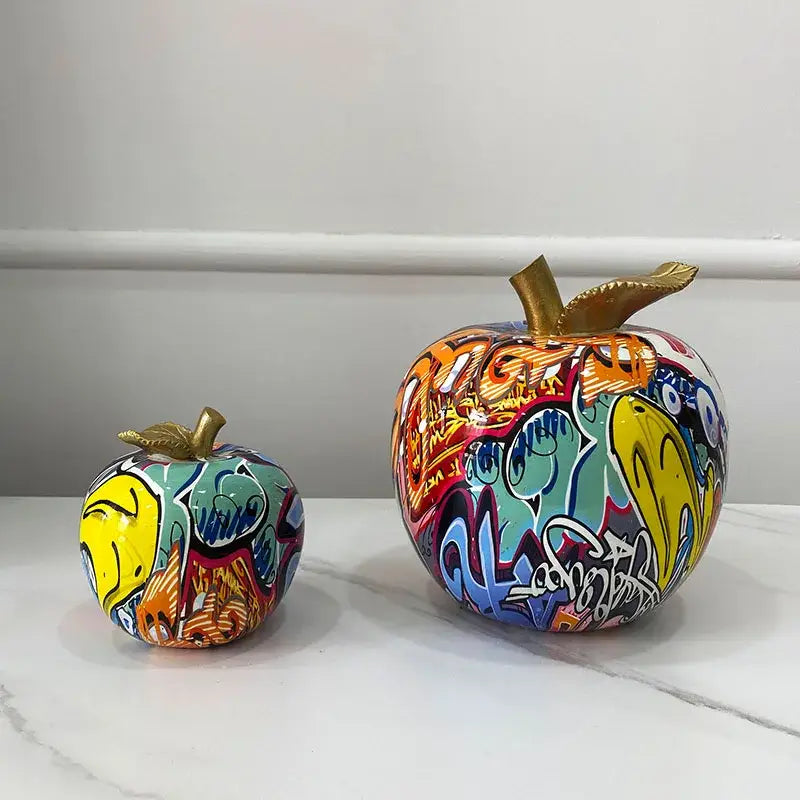 Vibrant decorbites apple figurines art ornament with golden stem on glossy ceramic in bold yellow blue orange and red colors