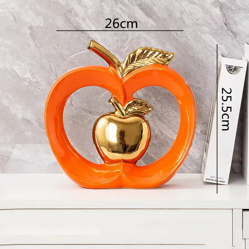 Vibrant orange DecorBites apple hollow ceramic candy jar with polished gold center and leaf accents for home decor