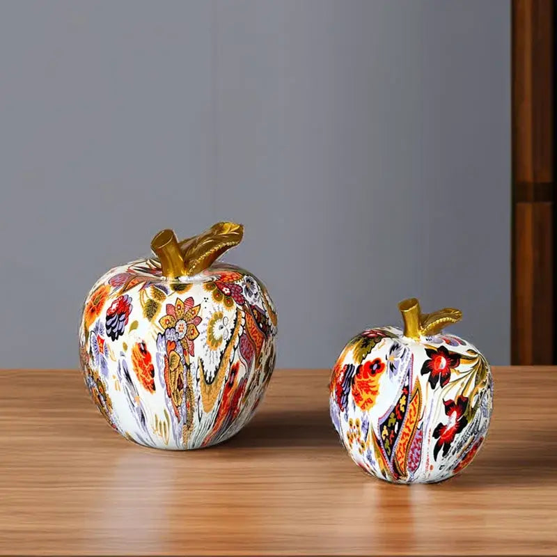 Two decorbites apple resin figures with vibrant floral patterns and gold-toned stems for home office decor