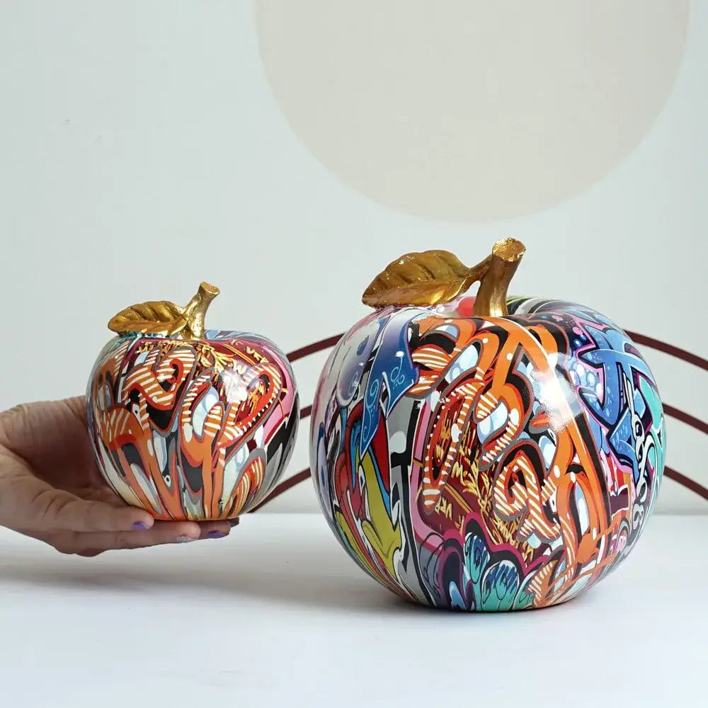 Decorbites apple sculpture featuring vibrant graffiti-painted ceramic apples with gold leaf stems resin ornament
