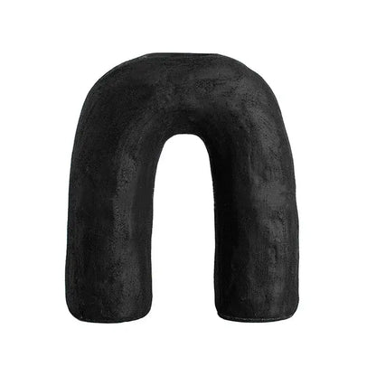 Black u-shaped neck pillow with soft textured fabric paired with decorbites arc ceramic geometric vase
