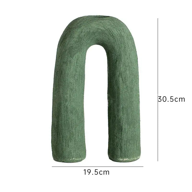 A matte green decorbites arc ceramic vase with textured u-shaped design and rounded ends for home decor