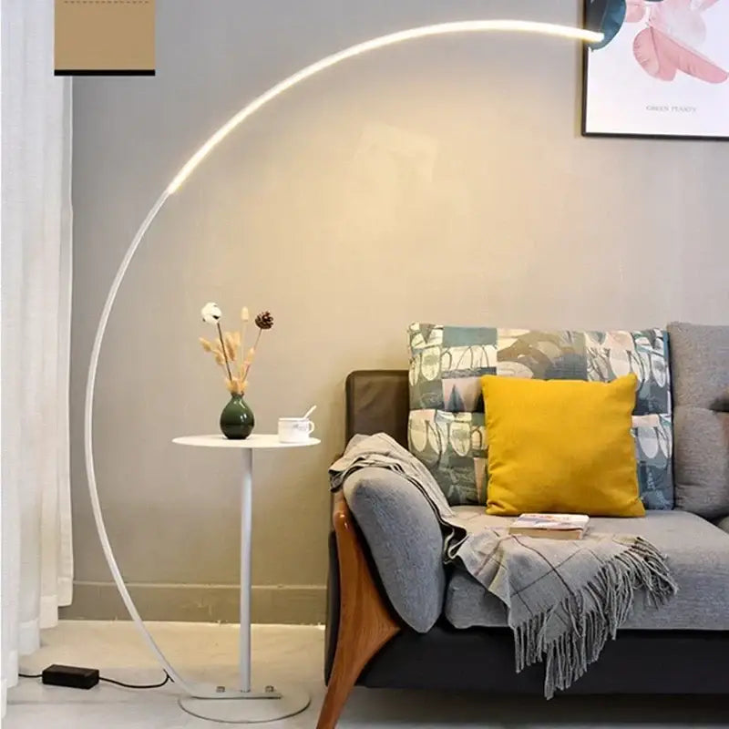 A sleek white curved frame floor lamp with integrated LED lighting in the DecorBites arc LED floor lamp design