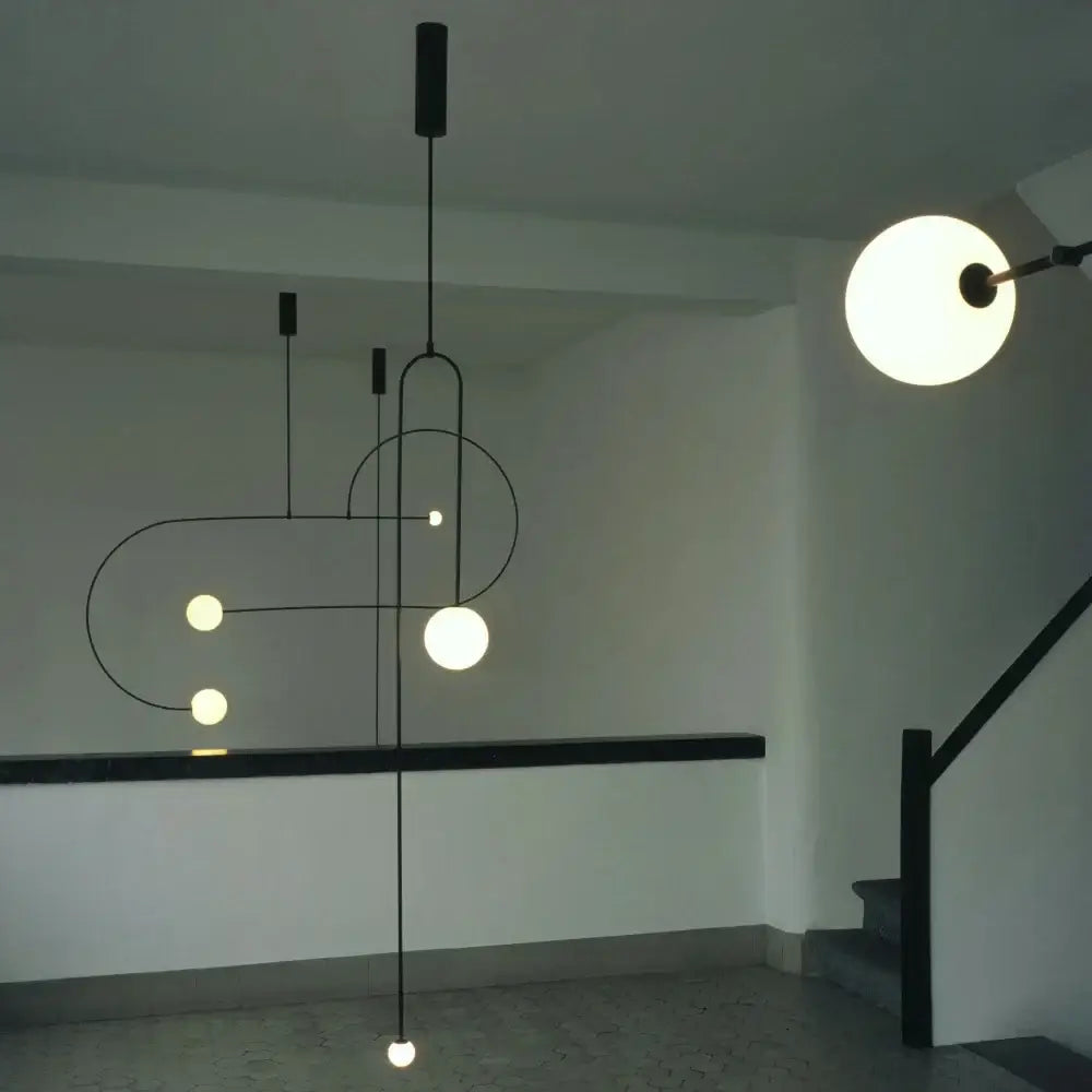 Modern black metal decorbites arc line chandelier with spherical frosted glass bulbs in geometric design for living spaces