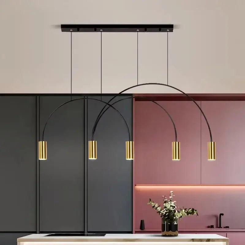 Modern black and gold decorbites arc pendant light chandelier with cylindrical LED bulbs hanging above kitchen island