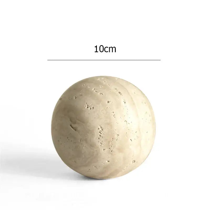 A 10cm diameter spherical decorbites archway shape travertine sculpture with textured light beige concrete surface for decor
