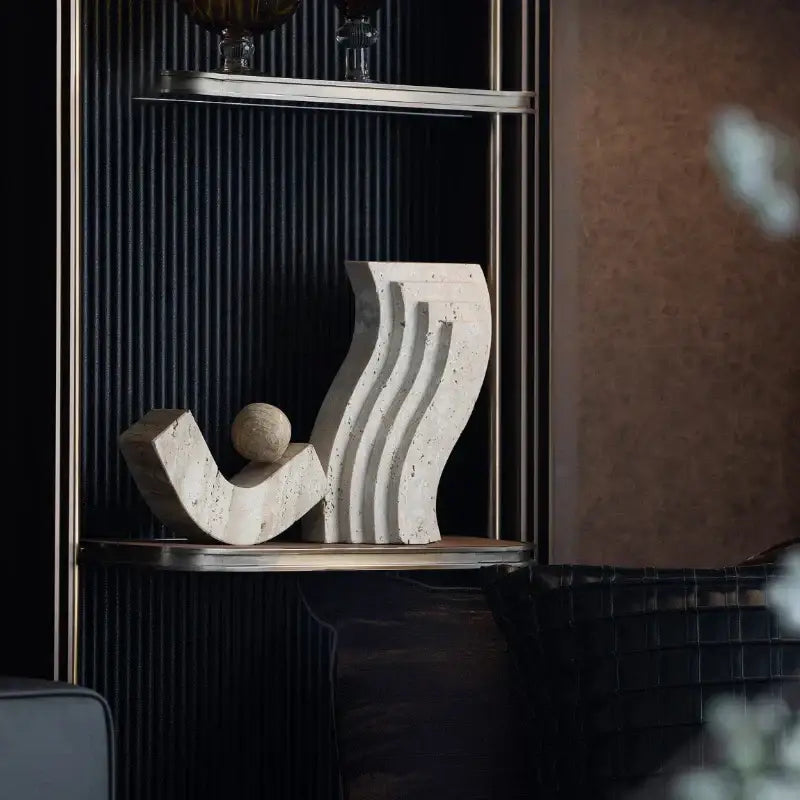 Cream-colored decorbites archway shape travertine sculpture figurine with flowing curves and a small spherical element