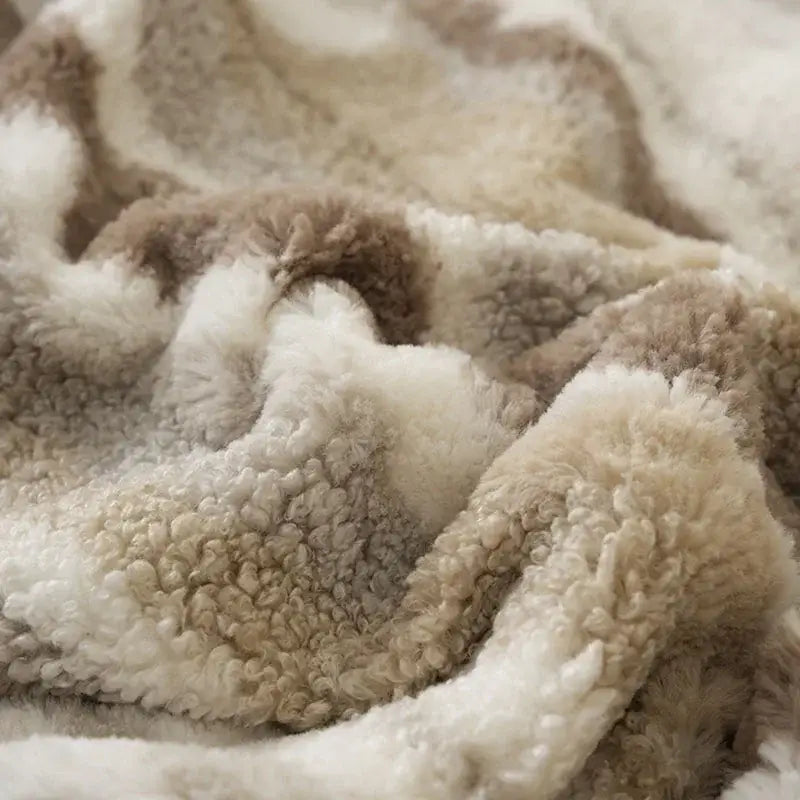 A cozy DecorBites Arctic Velvet faux rabbit throw blanket in creamy white and beige with a soft textured surface