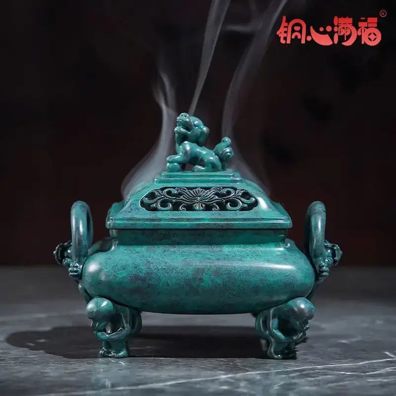 A teal-green bronze aromatherapy brass incense stove with lion-shaped handles and an ornate carved lid by decorbites