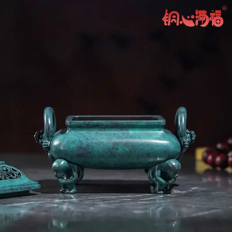 A jade-green decorbites aromatherapy brass incense stove with dragon handles and rectangular top opening for home use