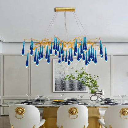 A decorbites art deco blue queen crystal chandelier with a golden frame and cascading blue glass teardrop pendants