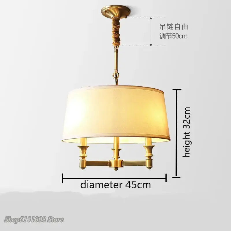 Gold-toned brass decorbites art deco pendant light with cream fabric shade and three candle-style bulbs for dining room lighting