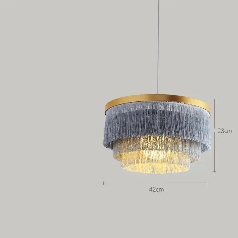 Decorbites art deco tiered chandelier with gold frame and gray cotton thread fringe emitting warm yellow light