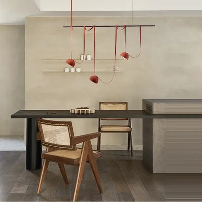 Decorbites™ art deco cross belt orange lustre hanging lamp with sleek red pendants above dining table