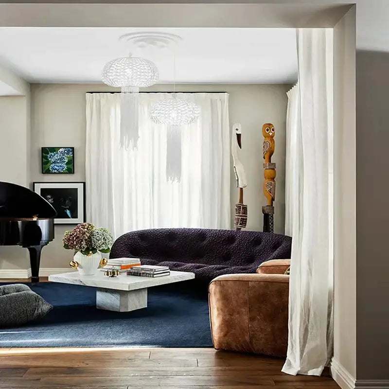 Dark purple tufted velvet sofa with rounded backrest paired with decorbites art deco dimmable hanging chandelier lighting