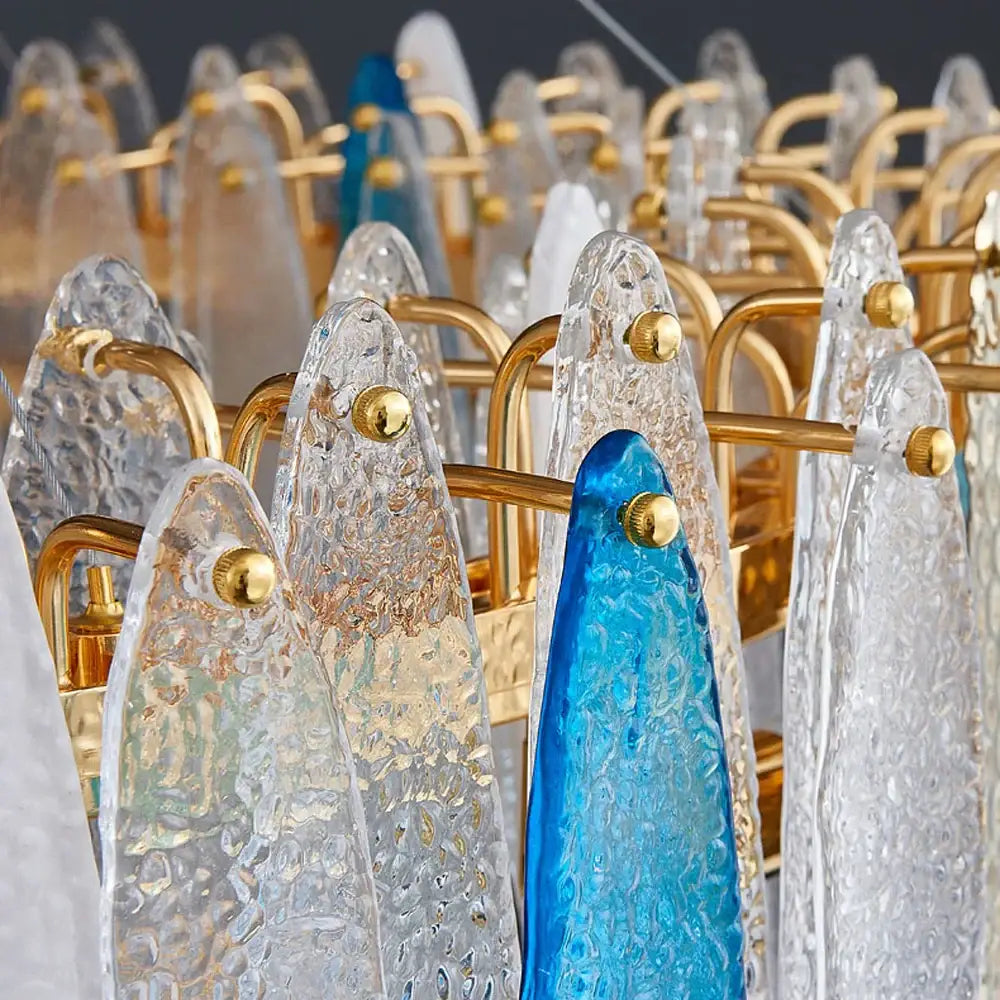 A decorbites art deco glass iron LED chandelier with clear and blue textured glass panels and gold-toned arms for dining room