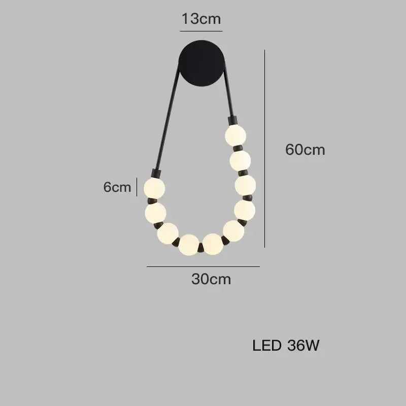 Black decorbites™ led wall sconce with cream glass bulbs and black cords forming an art deco teardrop shape