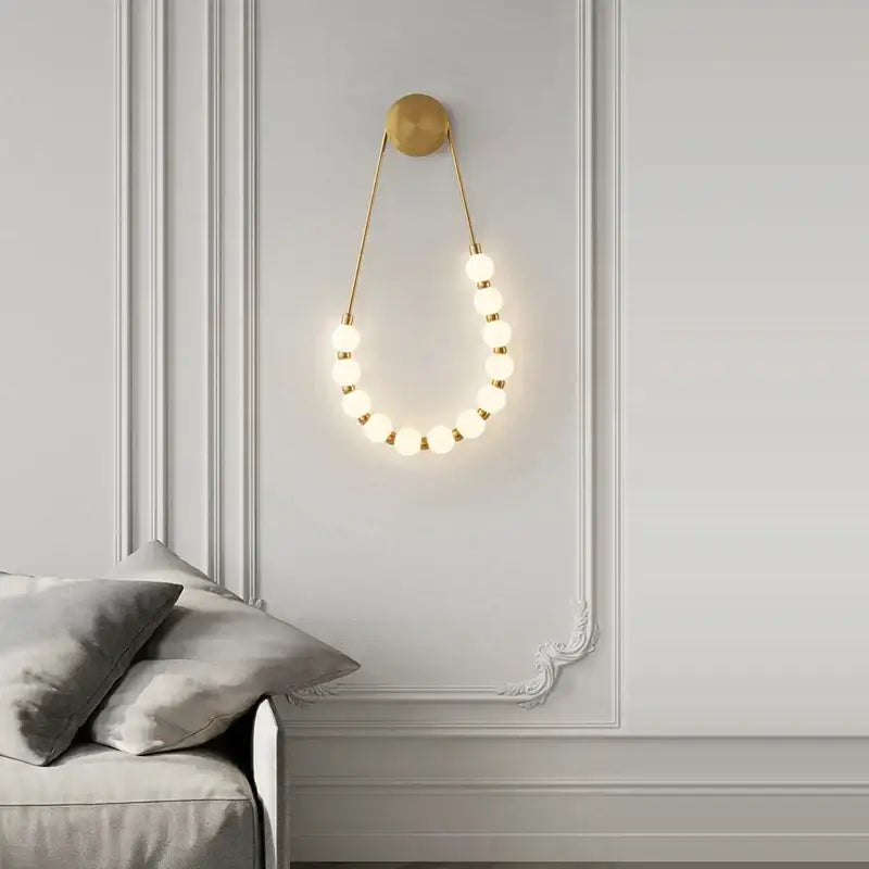 Gold-toned DecorBites™ Art Deco glass led wall sconce with circular warm glowing bulbs for bedroom and corridor lighting