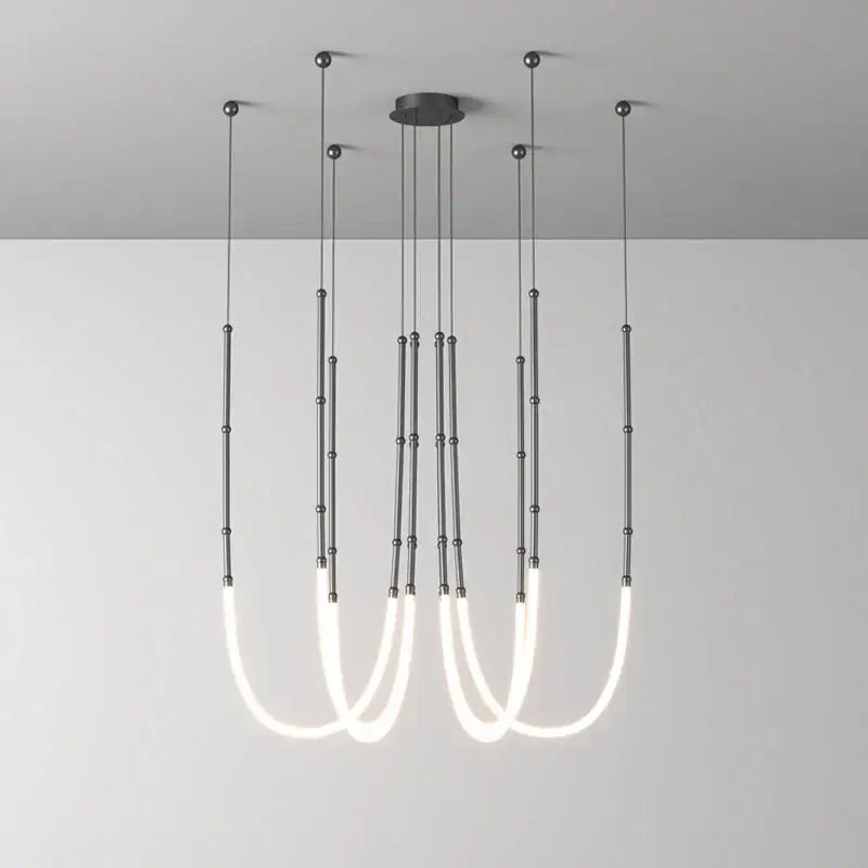 Modern minimalist DecorBites Art Deco pendant light with gold and black metallic rods and white curved LED tubes for dining room