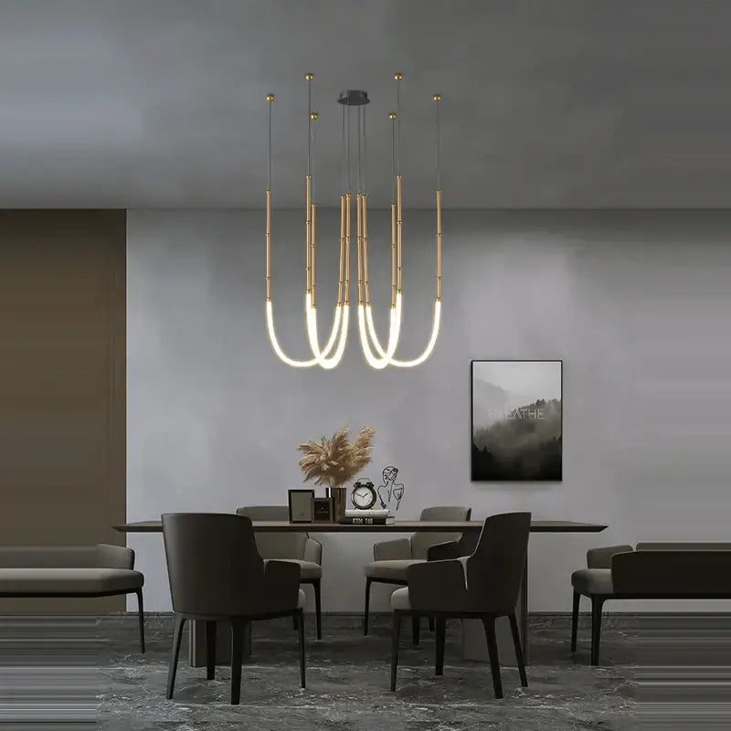 Modern gold-toned pendant light with sleek curved arms and integrated lighting by DecorBites Art Deco in gold black design