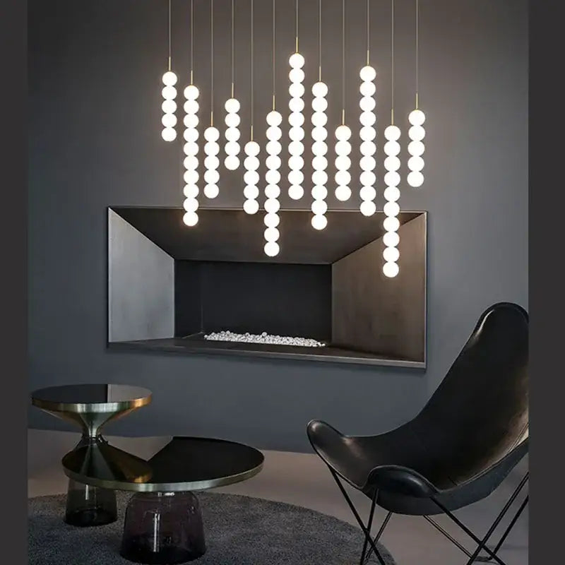 Decorbites art deco pendant light with vertical strands of glowing white glass pingpong bulbs on gold chrome cords