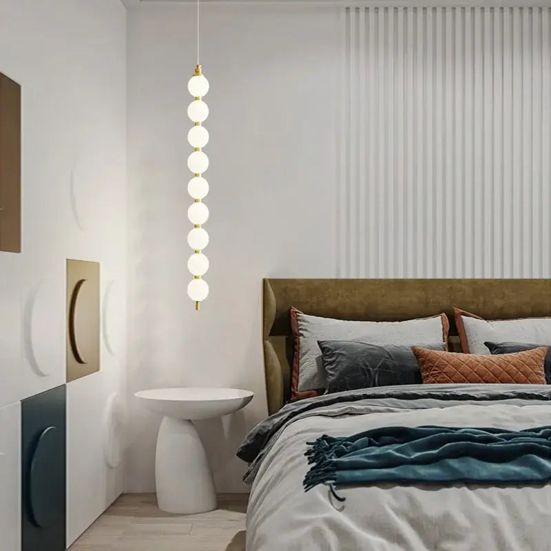 Modern pendant light with seven glowing white glass bulbs on a gold-toned decorbites art deco led fixture