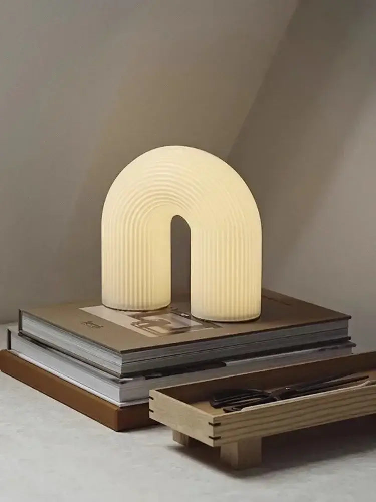 Cream-colored ribbed u-shaped table lamp with soft glow for living room featuring decorbites art deco white acrylic design