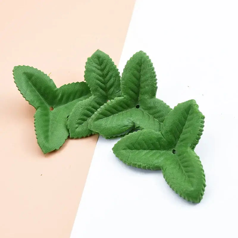 Green fabric leaf-shaped embellishments with stitched edges and holes from decorbites artificial green silk roses for diy decor