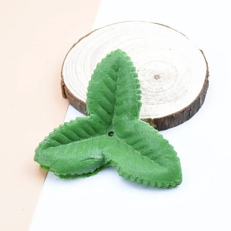 Green three-leaf fabric charm with textured surface and central hole from decorbites artificial green silk roses collection