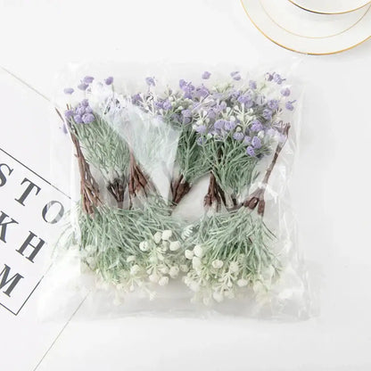 A clear plastic bag containing decorbites artificial gypsophila plants with lavender and white blossoms set of 12
