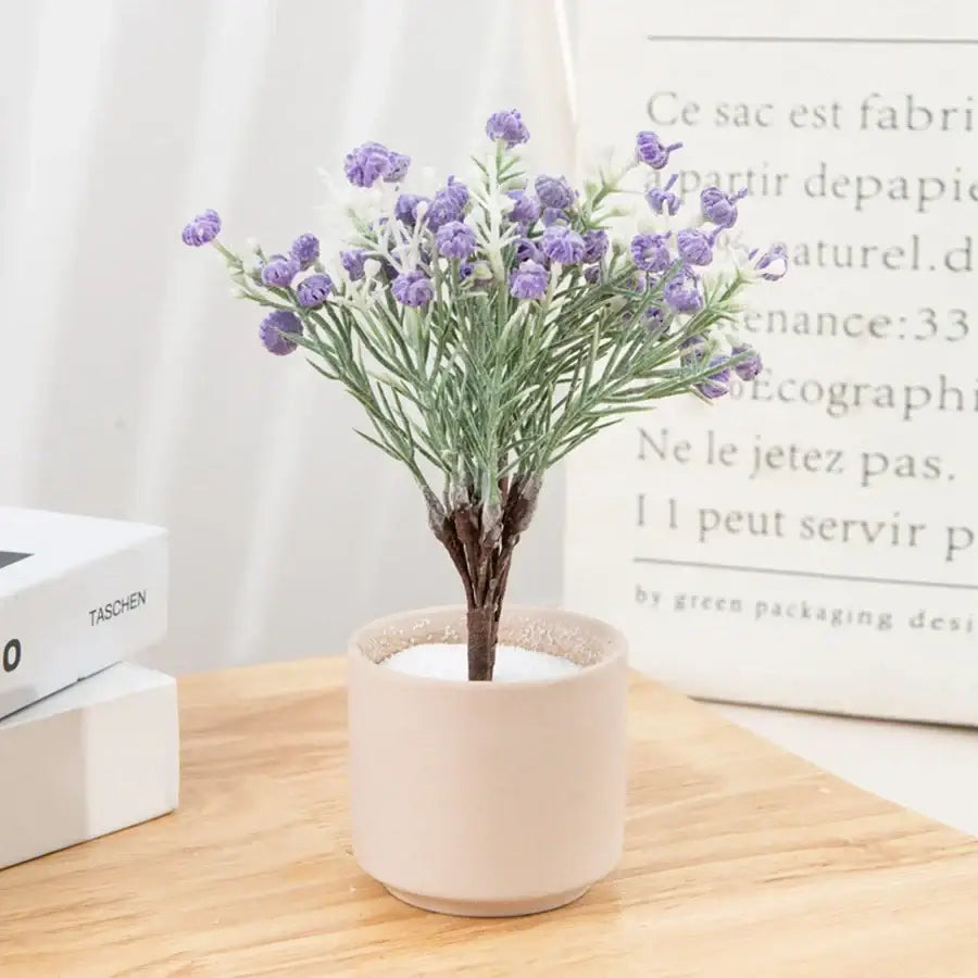 A delicate artificial gypsophila plant with purple blooms in a beige ceramic pot for home decor and weddings