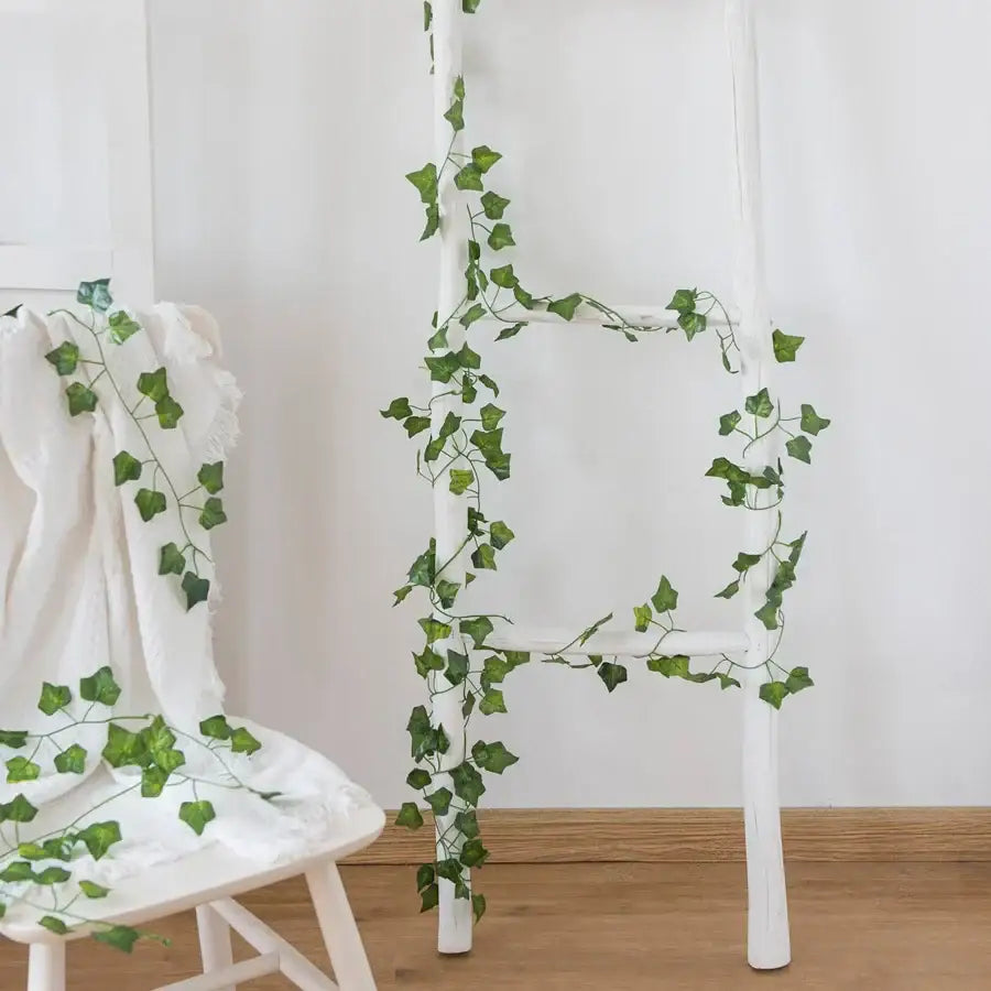 White wooden ladder decorated with decorbites artificial hanging christmas garland green silk leaves for home use