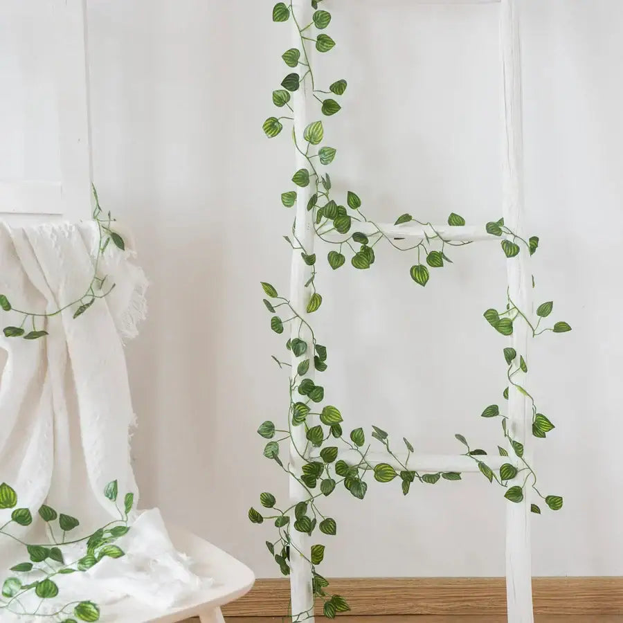 Decorbites artificial hanging green silk ivy vine with glossy heart shaped leaves draped over white ladder for christmas decor