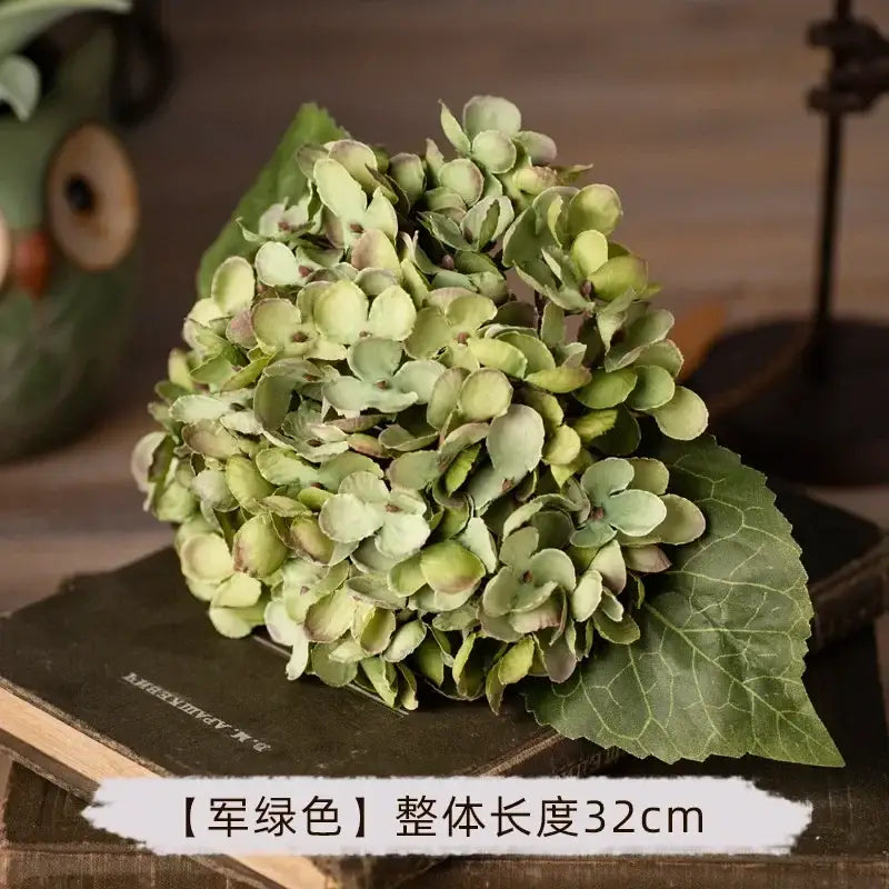 A cluster of decorbites artificial hydrangea silk flowers in muted army green with purple undertones made from realistic fabric
