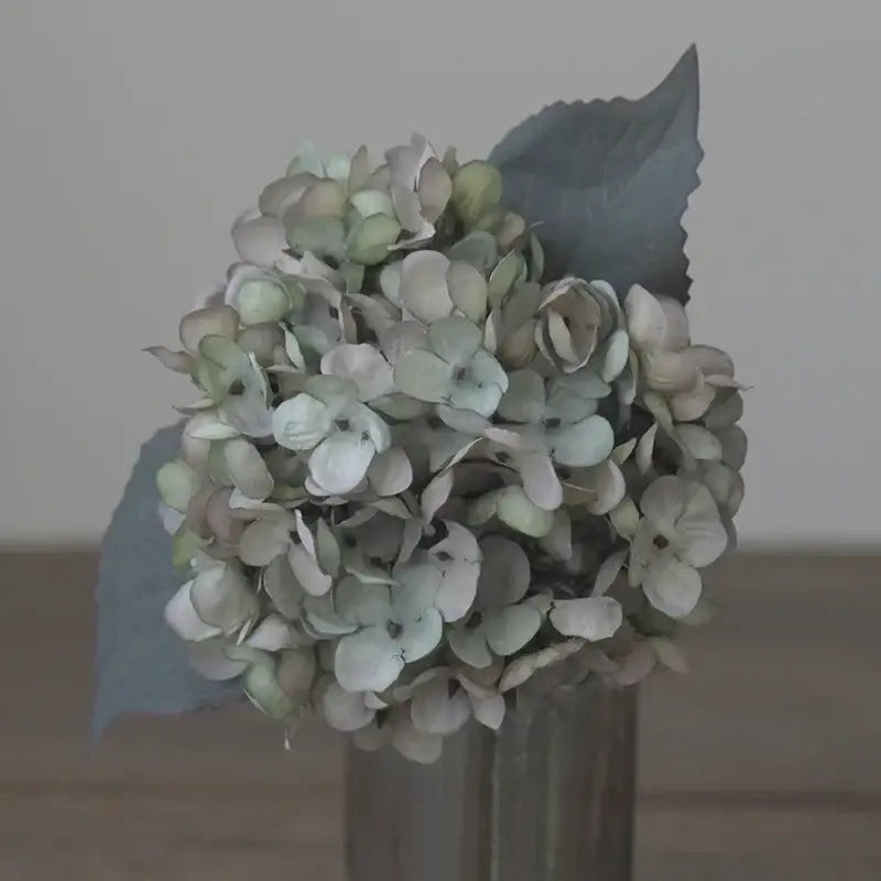 Decorbites artificial hydrangea silk flower arrangement in muted greens and whites in a simple cylindrical vase