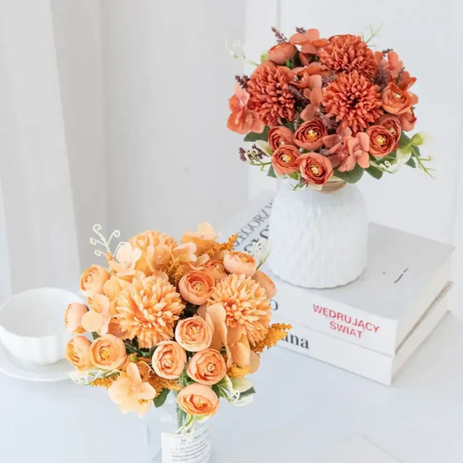 A vibrant orange and peach decorbites artificial hydrangea tea rose bouquet in a textured white ceramic vase for decor