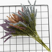 A bouquet of DecorBites™ artificial lavender plants in purple gray and brown with green foliage for home decor and wedding diy