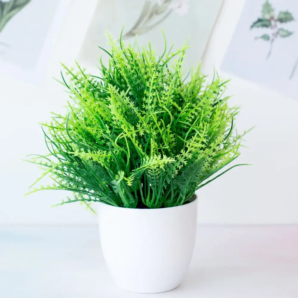 A vibrant green decorbites artificial mini plant bonsai in a sleek white ceramic pot for desktop decor