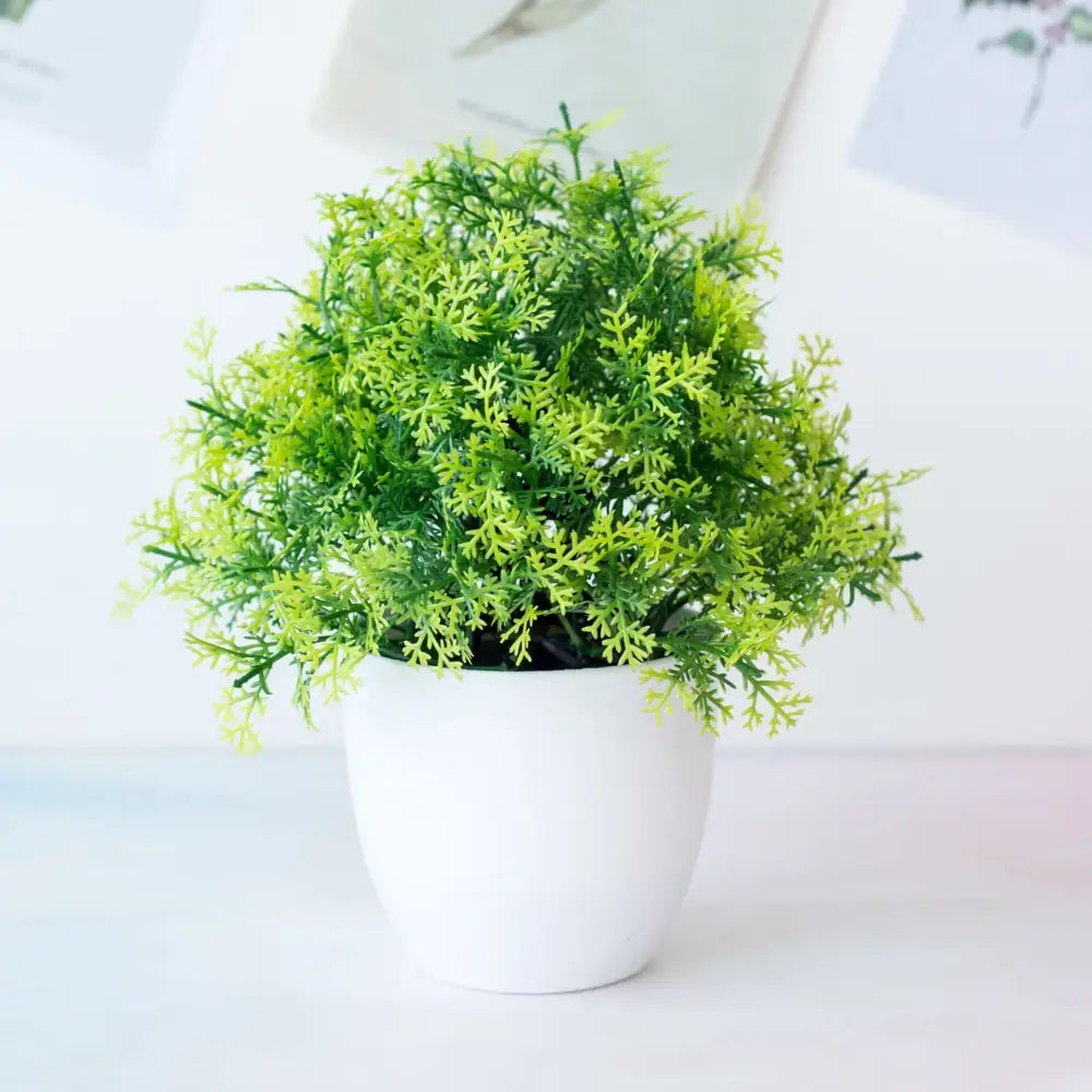 A lush green decorbites artificial mini plant bonsai with feathery foliage in a white ceramic pot for desktop decor