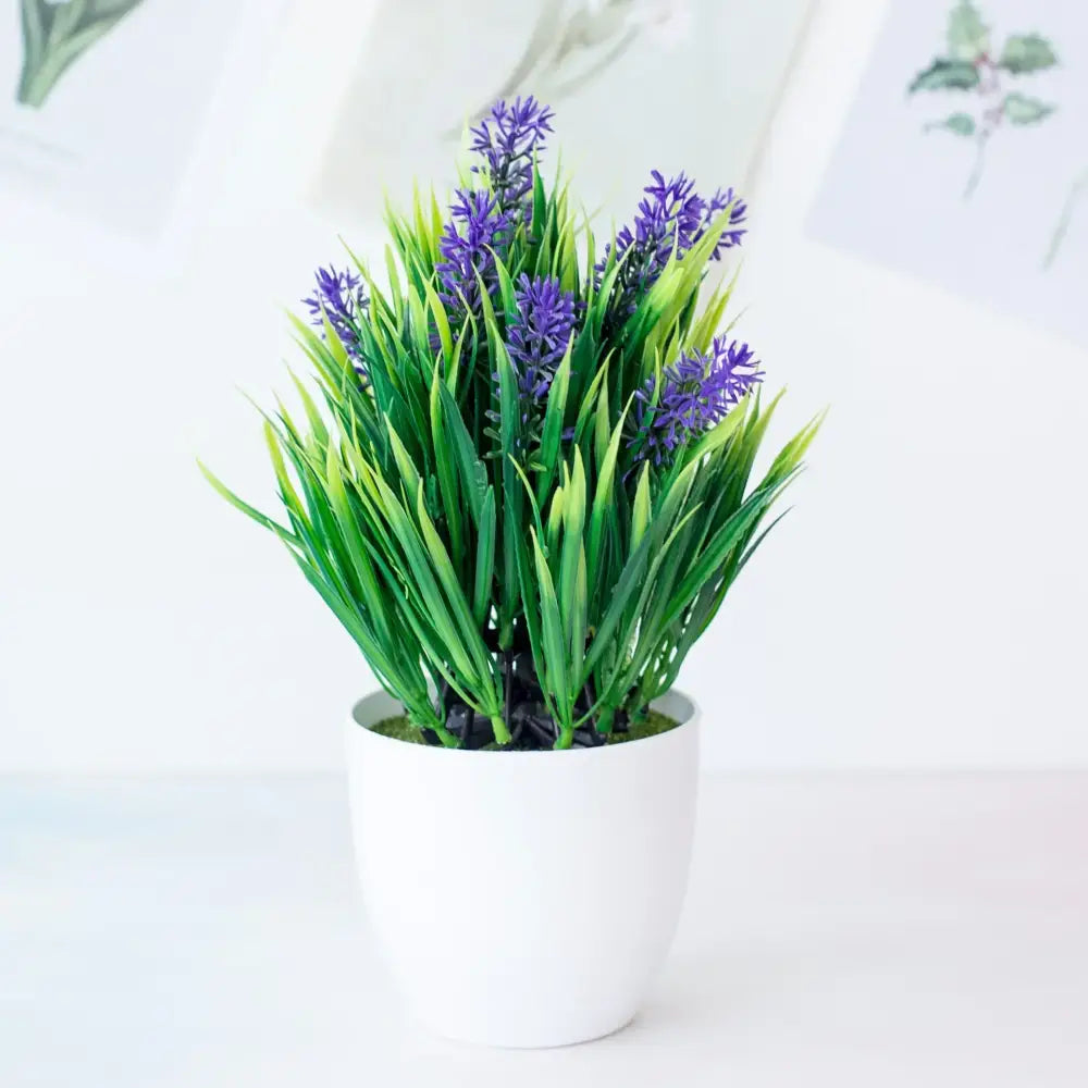 Decorbites artificial mini plant featuring lush green grass and purple flowers in a white ceramic pot for desktop decor