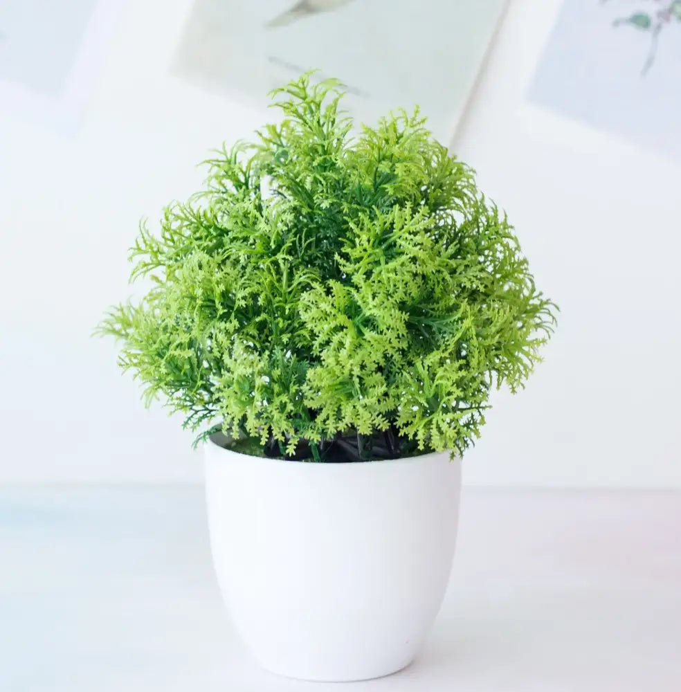 A lush vibrant green decorbites artificial mini plant bonsai in a sleek white ceramic pot for desktop decor