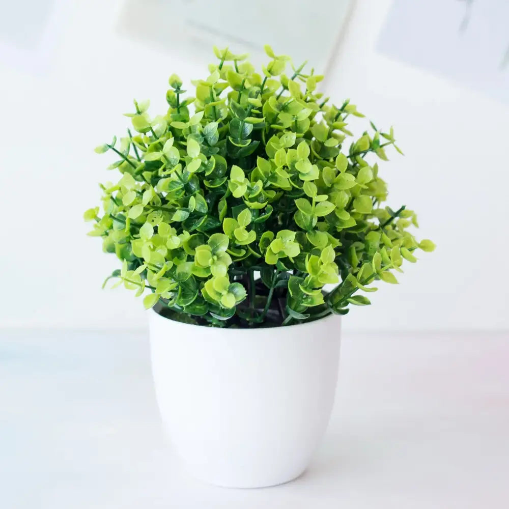 A decorbites artificial mini green plant bonsai with dense foliage in a white ceramic pot for desktop decor