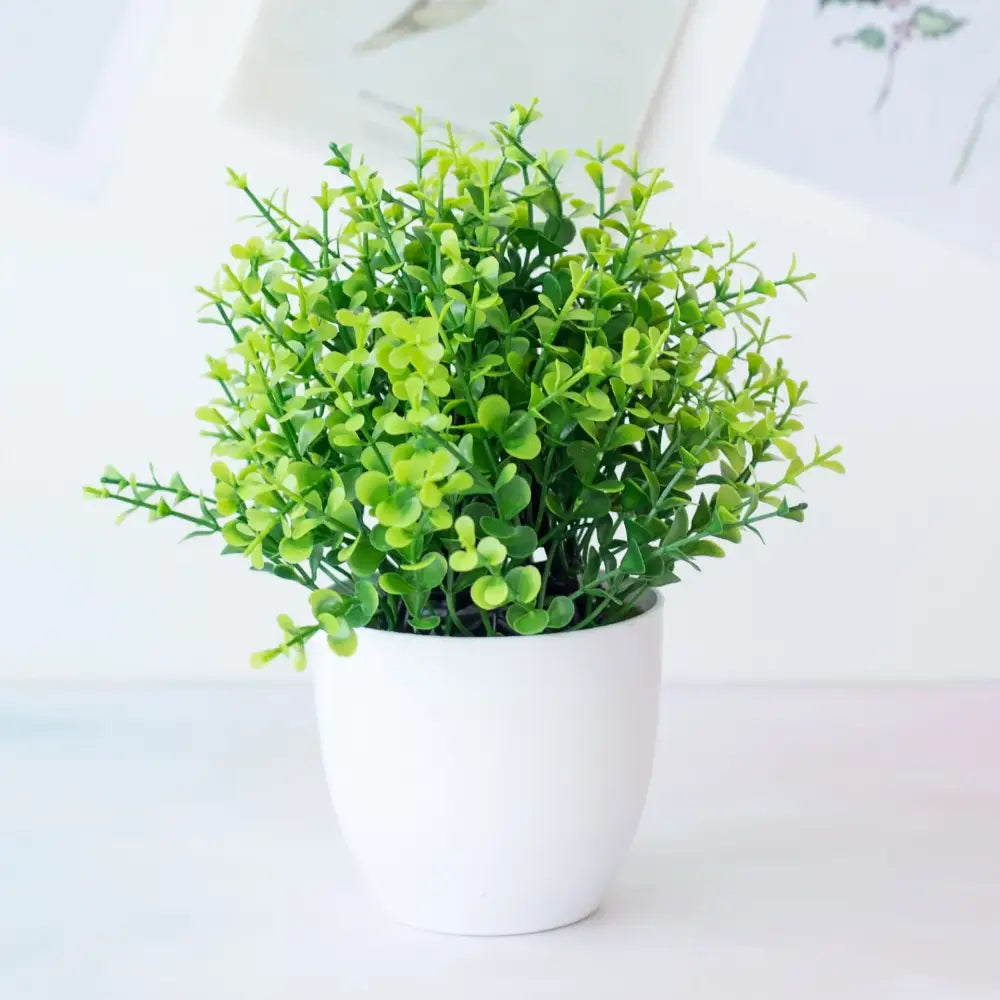 A vibrant green decorbites artificial mini plant bonsai with dense foliage in a white ceramic pot for desktop decor