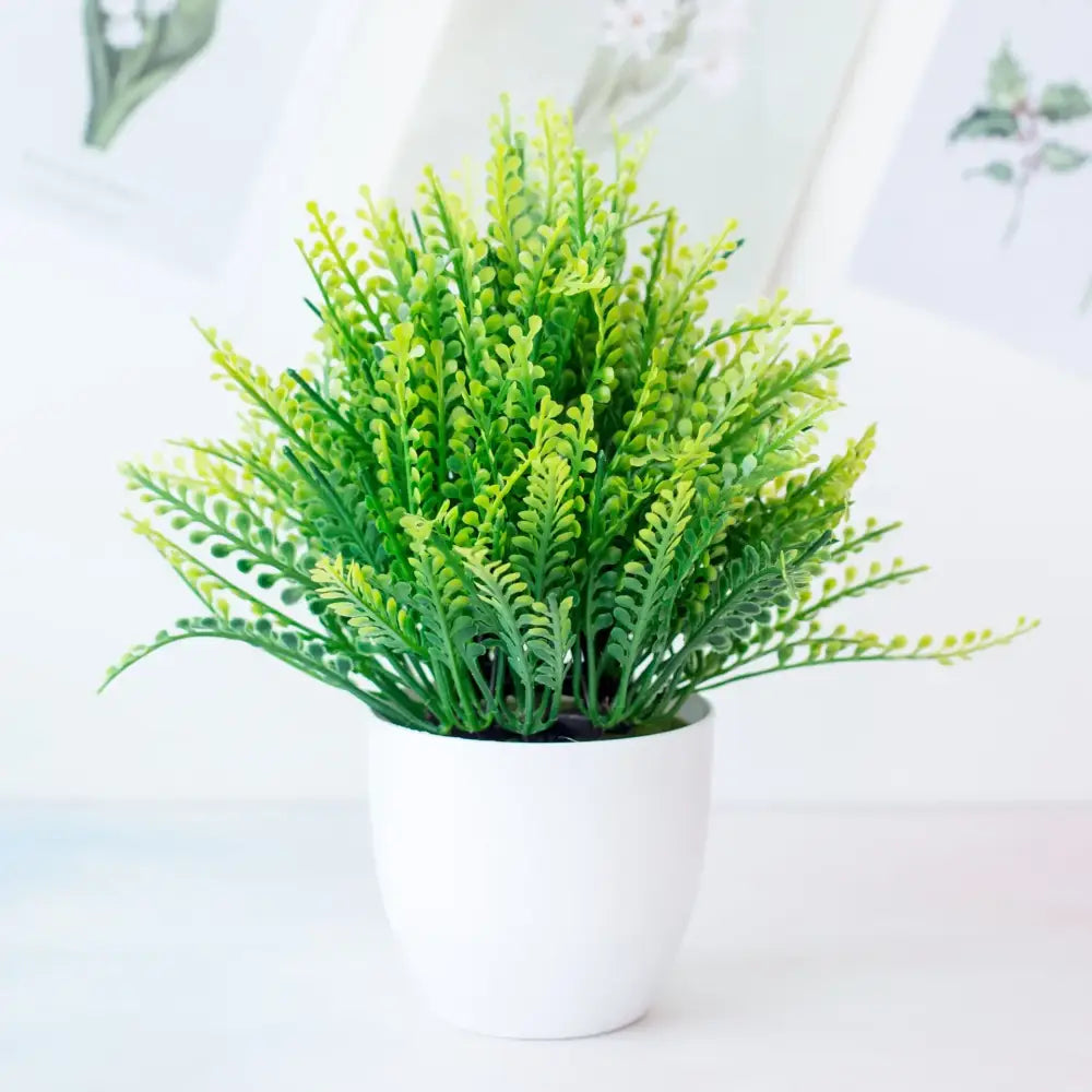 A vibrant green decorbites artificial mini plant bonsai with feathery fronds in a white ceramic pot for desktop decor