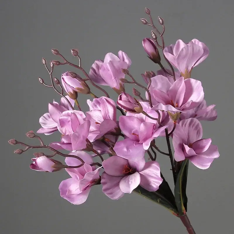 A delicate cluster of pink decorbites artificial orchid magnolia bouquet with slender stems for wedding home decor
