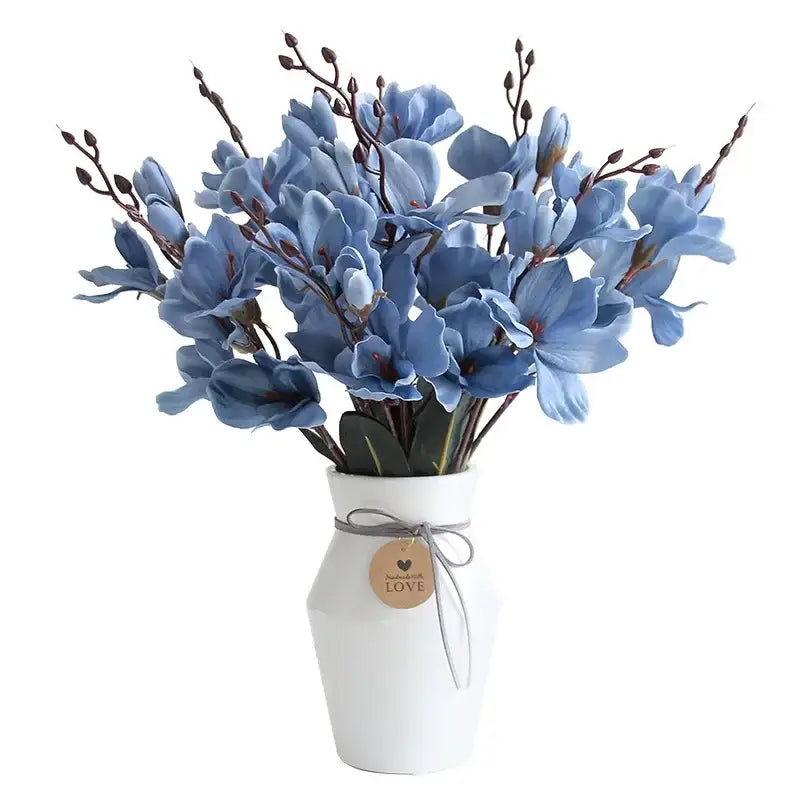 A delicate decorbites artificial orchid magnolia bouquet of light blue flowers in a white ceramic vase for home decor